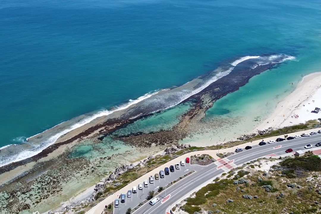 Aerial image of Yanchep Lagoon, a beach partially enclosed by rock formations.