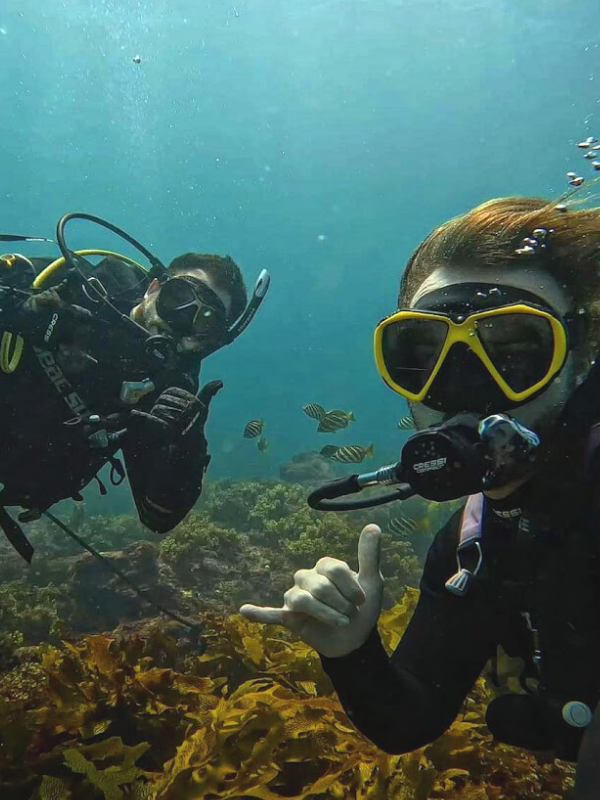 Two men scuba diving smiling at the camera